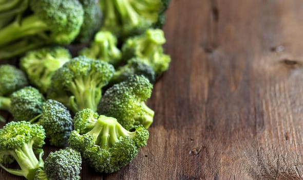 Fresh broccoli on old wooden table close up