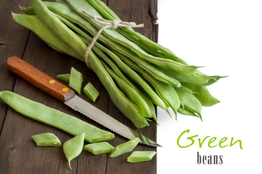 Piattoni green beans with knife on the old wooden table