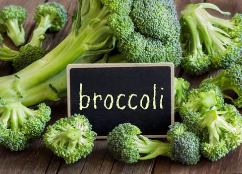 Fresh broccoli small chalkboard on old wooden table