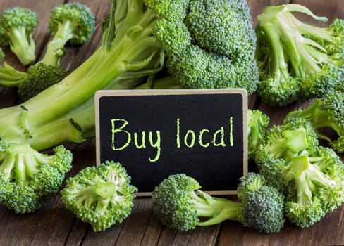 Fresh broccoli small chalkboard on old wooden table