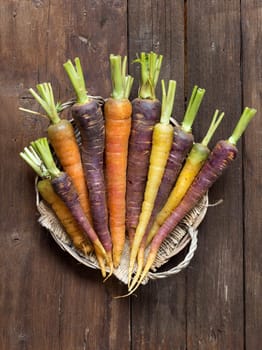 Fresh organic rainbow carrots on a wooden table