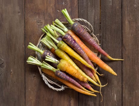 Fresh organic rainbow carrots on a wooden table