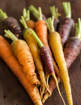Fresh organic rainbow carrots on a wooden table