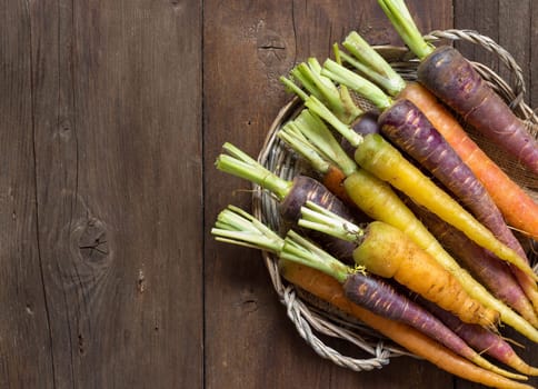 Fresh organic rainbow carrots on a wooden table