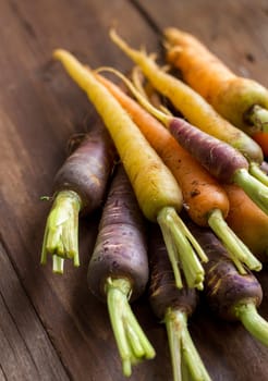 Fresh organic rainbow carrots on a wooden table