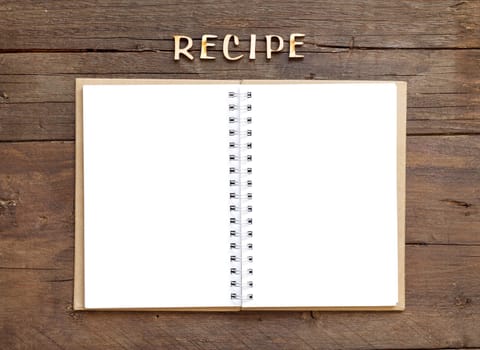 Recipes word with notebook on wooden background
