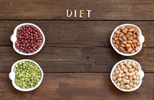 Legumes in bowls and the word Diet on wood