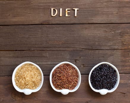 Variety of rice and word Diet on a wooden background