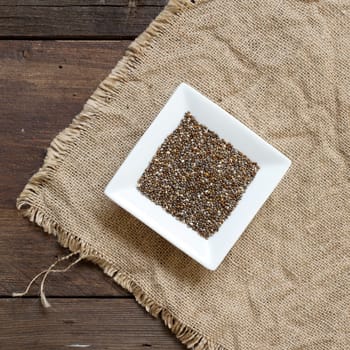 Chia seeds in bowl on a burlap background