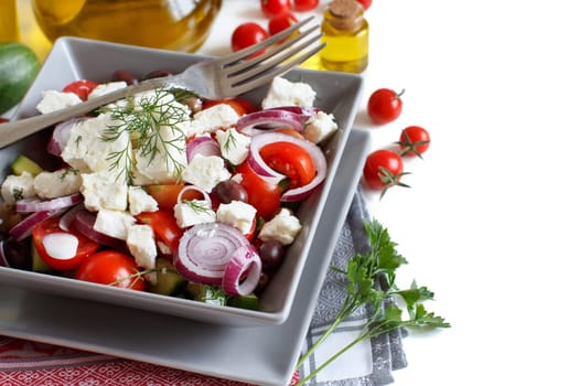 Greek salad with tomatoes, feta cheese, cucumbers, onions and olives