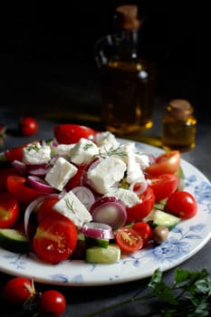 Greek salad with tomatoes, feta cheese, cucumbers, onions and olives