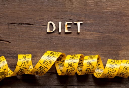 The word of Diet and measuring type on wooden background