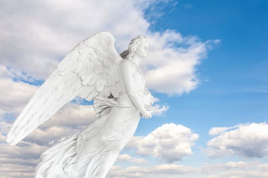 Photo montage with 150 year old Angel cemetery statue on blue sky with clouds