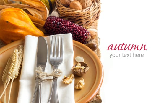 Autumn table setting with corn, nuts and pumpkins