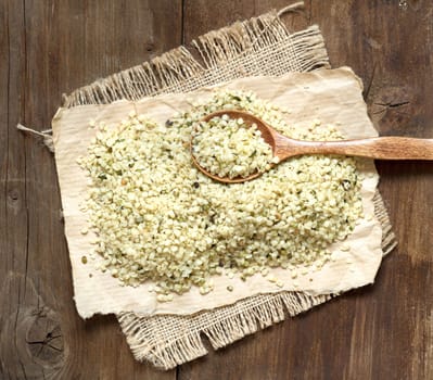 Hemp seeds with a spoon on a wooden table