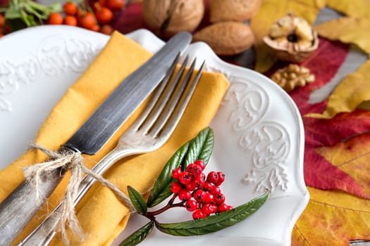 Autumn rustic table setting with berries, leaves and nuts