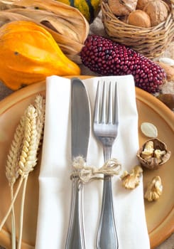Autumn table setting with corn, nuts and pumpkins