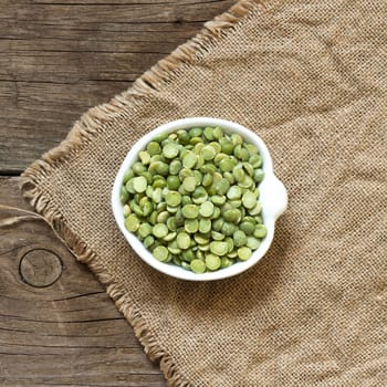 Dried Green Split Peas in a bowl on a wooden table