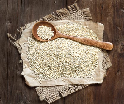 Organic quinoa with a spoon on a wooden table