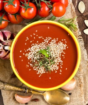 Fresh tomatoe soup with vegetables on a wooden table