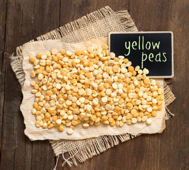 Yellow peas with a small chalkboard on a wooden table