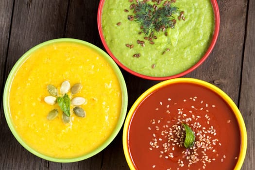 Three fresh soups - tomatoes, pumpkin and green peas soups