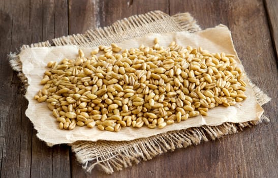 Raw organic spelt on a wooden table