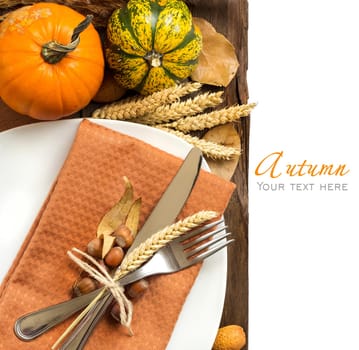 Autumn table setting with nuts, pumpkins and wheat