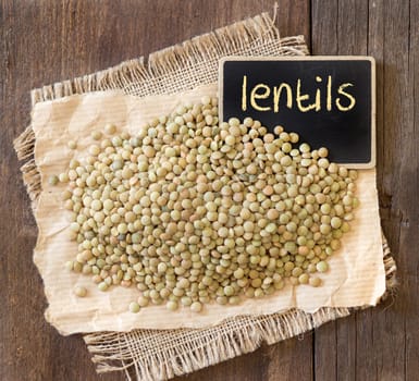 Lentils on wooden table with small chalkboard