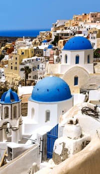 Oia town on Santorini island, Greece. Traditional and famous houses and churches with blue domes over the Caldera, Aegean sea