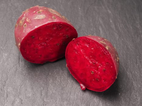 Fresh prickly pear on a dark slate background