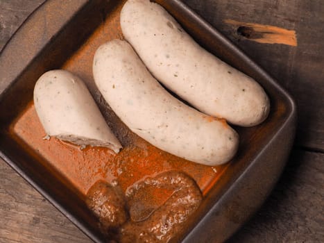 Bavarian white sausages with sweet mustard in a rustic bowl, Oktoberfest food