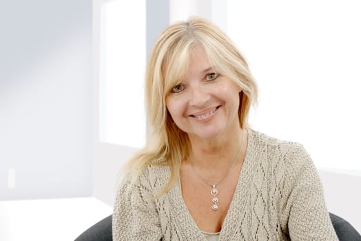Portrait of blond mature woman relaxing in sofa