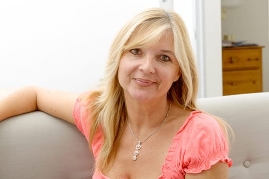 Portrait of blond mature woman relaxing in sofa