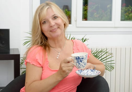 Smiling senior woman drinking tea at home