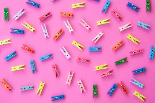 Small colorful ash clips scattered on pink