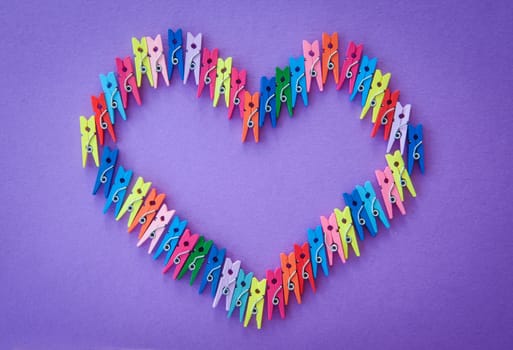 Colorful heart-shaped ash clips on purple