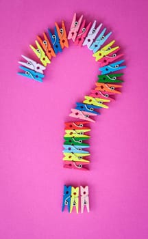 Colorful ash clips in the form of a question mark on pink
