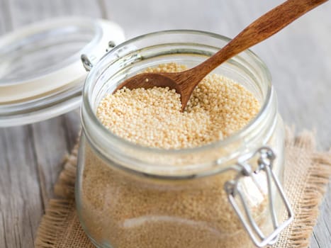 Millet in a glass jar with a spoon