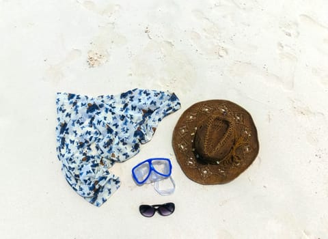 The straw hat, mask, sun glasses and dress on a tropical beach