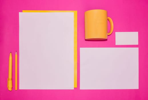 Mock-up business template with cards, papers, pen on pink background.