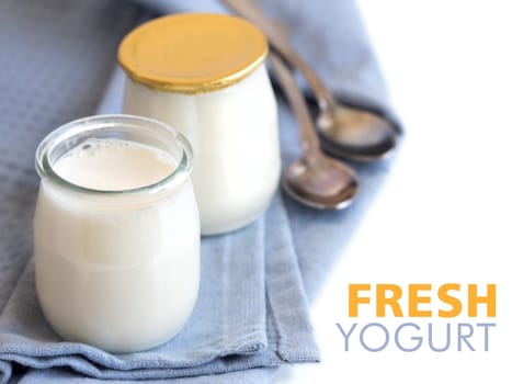 Jars of fresh natural yogurt on the light blue napkin