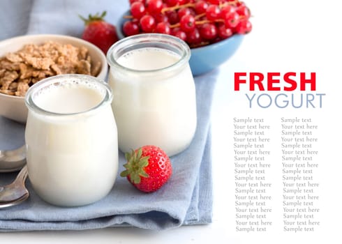 Jars of fresh natural yogurt, berries and muesli in bowls