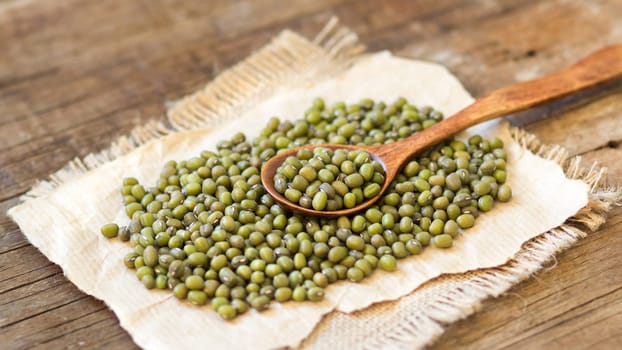 Mung beans and spoon on a wooden table