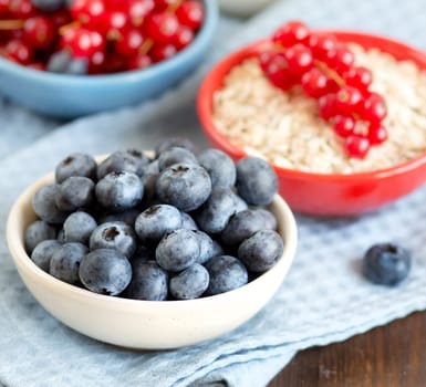 Blueberries, red currants nad cereals in bowls - healthy breakbast