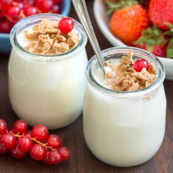 Jars of fresh natural yogurt with berries and muesli