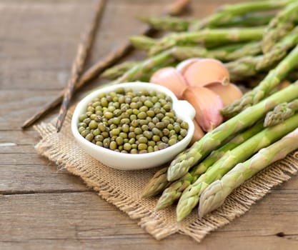 Mung beans, garlic and asparagus on a wooden table