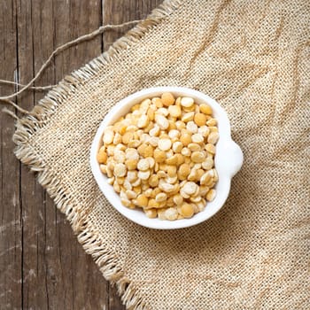 Yellow peas in a bowl on burlap