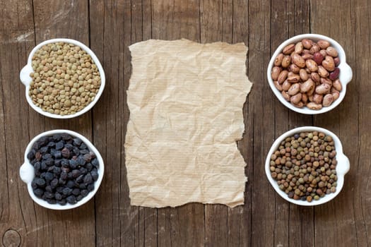 Variety or legumes and paper on a wooden table