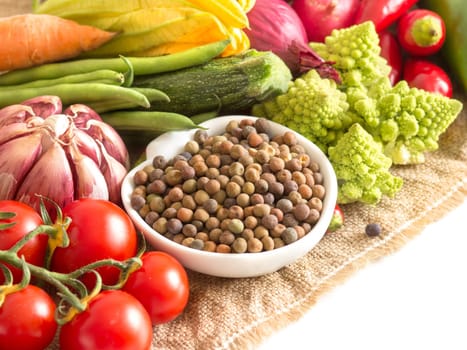 Raw organic roveja beans and vegetables isolated on white